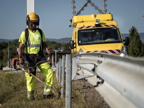homme en jaune en train de faucher